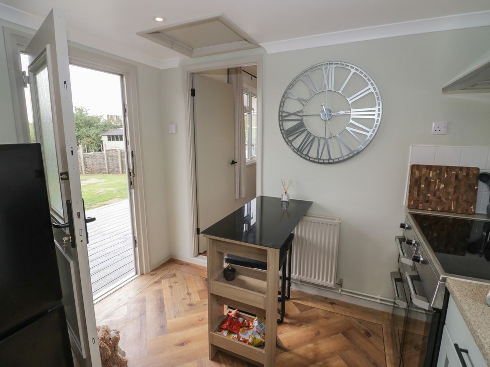 A kitchen with a door opening to the garden at 3 Swedish House Walgrave
