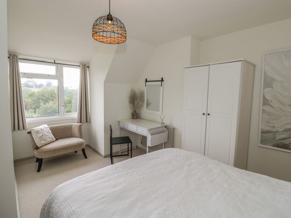 A bedroom with a bed, chair, table and wardrobe at 3 Swedish House Walgrave