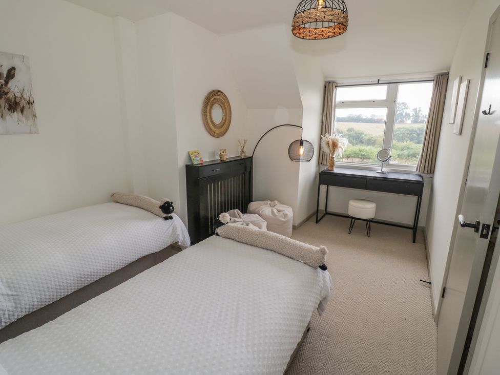 A bedroom with two beds and a desk at 3 Swedish House in Walgrave