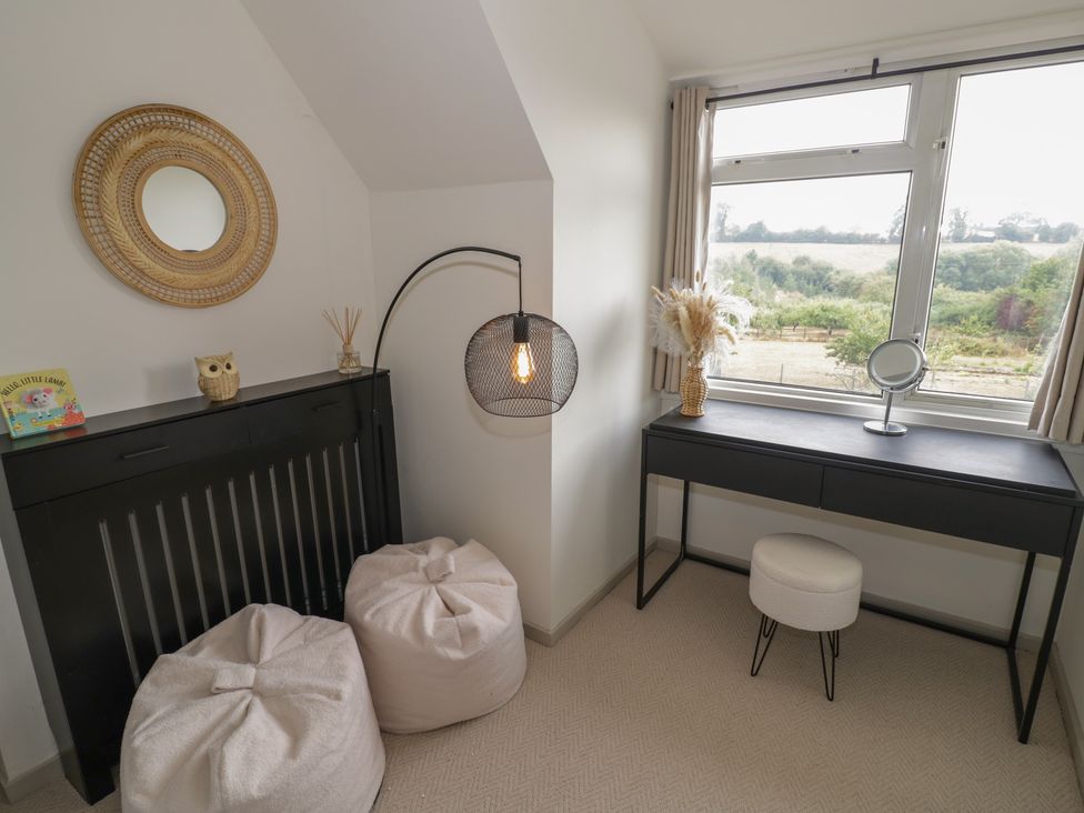 A bedroom with a dressing table and poufs at 3 Swedish House in Walgrave