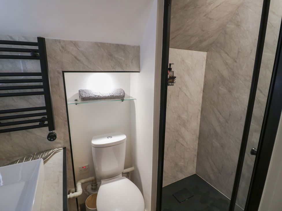A bathroom featuring a toilet and a shower at 3 Swedish House in Walgrave
