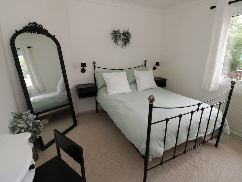 A bedroom with a bed and mirror at 3 Swedish House in Walgrave