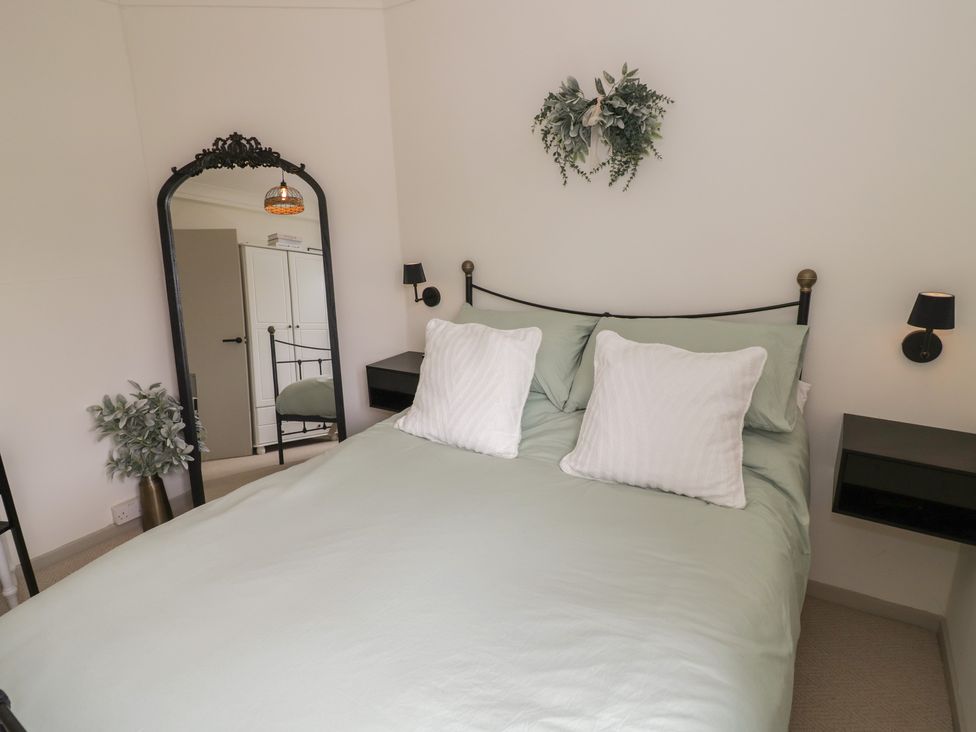 A bedroom with a bed and a mirror at 3 Swedish House in Walgrave