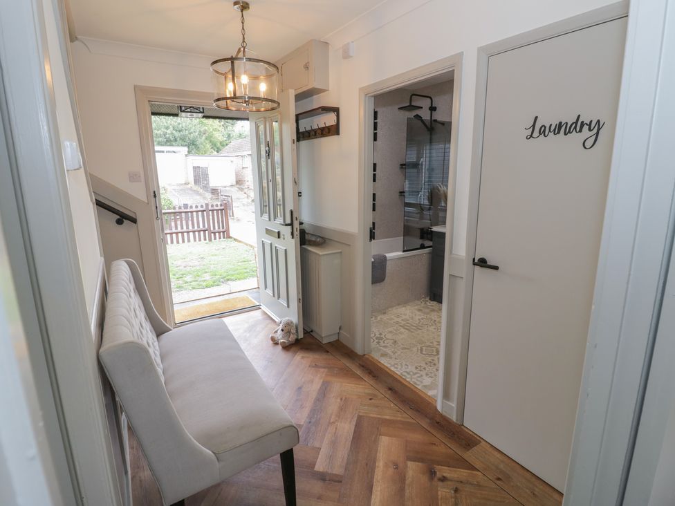 A hallway with a bench and laundry door at 3 Swedish House Walgrave