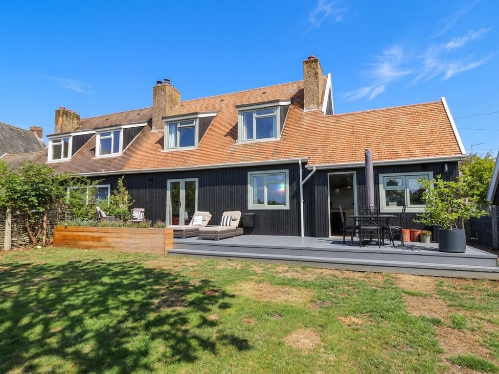 An outdoor view of a house with a deck and seating at 3 Swedish House Walgrave