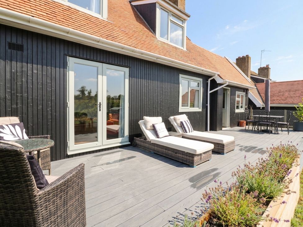An outdoor terrace with sun loungers and a table at 3 Swedish House Walgrave