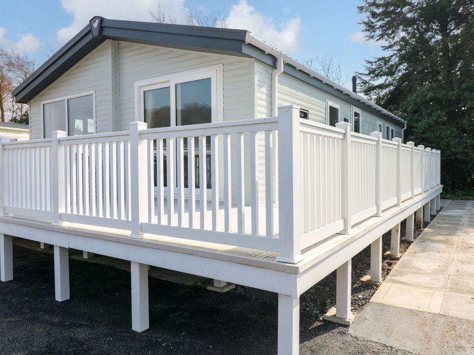 An exterior view of a house with a deck and railing at Dukes Meadow in Carmarthen