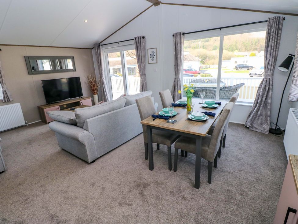 A living room with a sofa and dining area at Dukes Meadow in Carmarthen