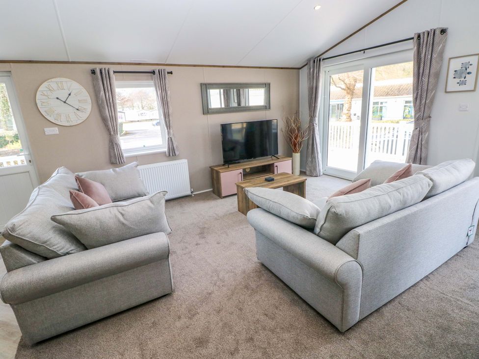 A living room with sofas and a television at Dukes Meadow in Carmarthen