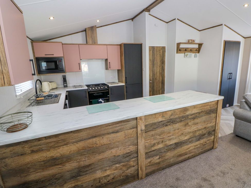 A kitchen with modern appliances and a kitchen island at Dukes Meadow in Carmarthen