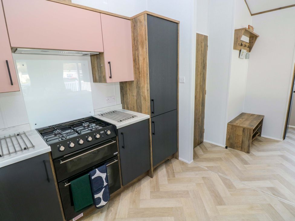 A kitchen with cabinets and an oven at Dukes Meadow in Carmarthen
