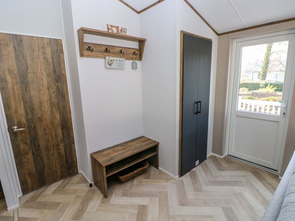 A hallway with a bench and hooks at Dukes Meadow in Carmarthen