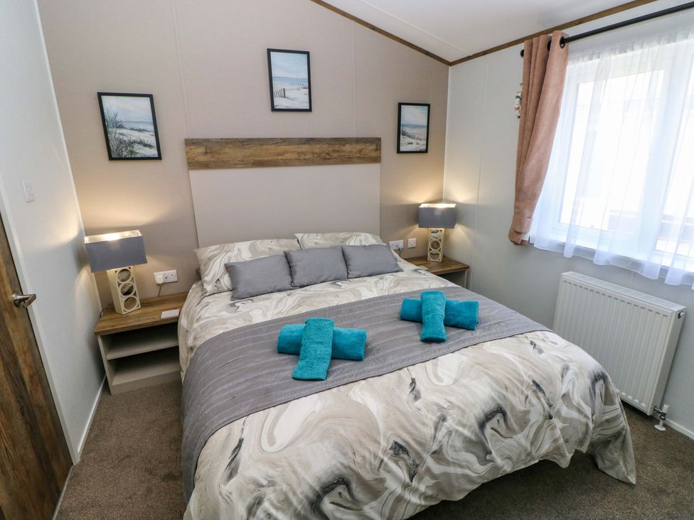 A bedroom with a bed and lamps at Dukes Meadow in Carmarthen