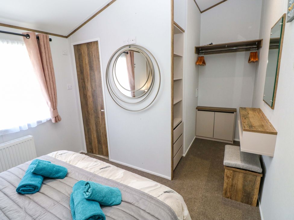 A bedroom with a bed and storage at Dukes Meadow in Carmarthen