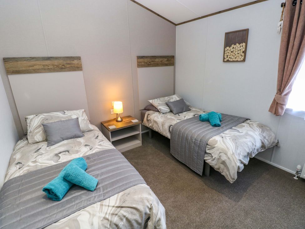 A bedroom with two beds and a lamp at Dukes Meadow in Carmarthen