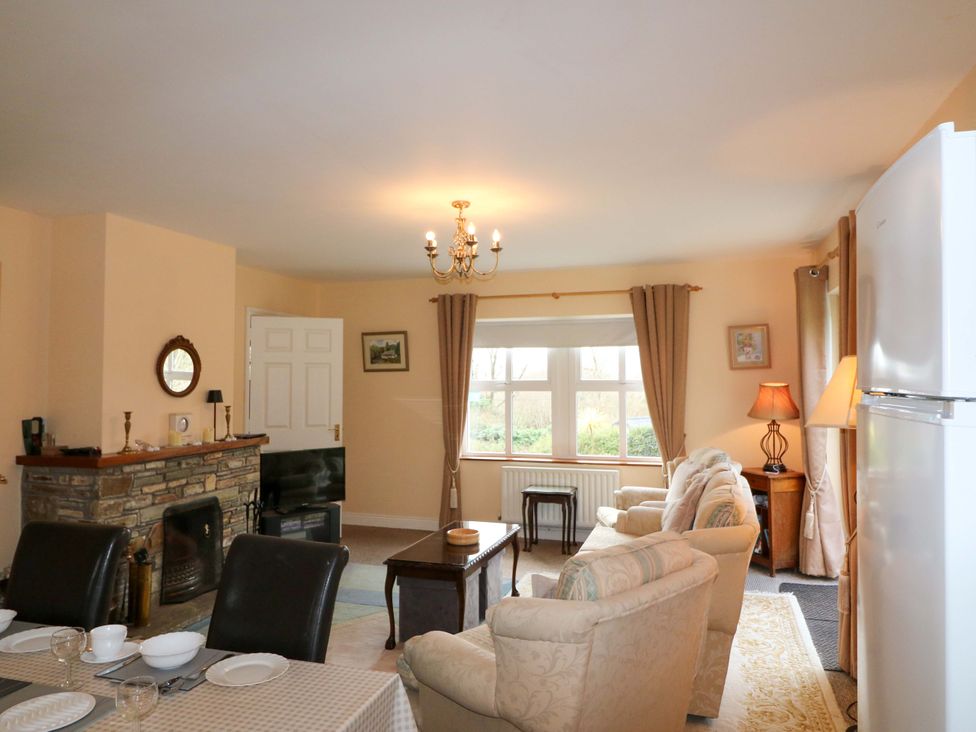 A living room with a sofa and dining table at Lugdine Lodge in Glengarriff