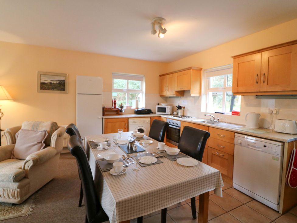 A kitchen with a table and chairs at Lugdine Lodge in Glengarriff