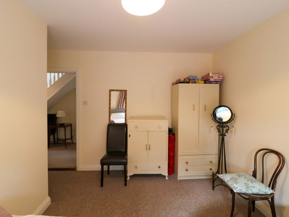 A bedroom with a wardrobe and a mirror at Lugdine Lodge Glengarriff