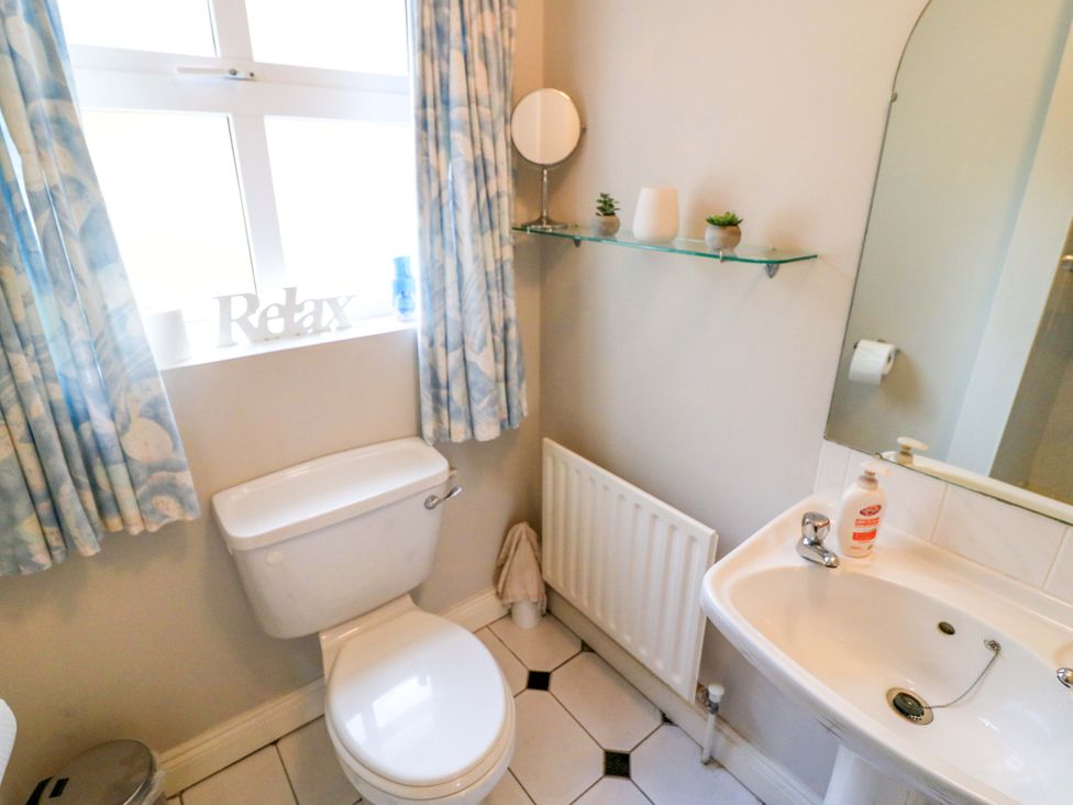 A bathroom with a toilet and sink at Lugdine Lodge in Glengarriff
