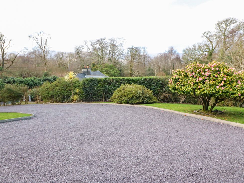 An outdoor area with a gravel driveway and bushes at Lugdine Lodge Glengarriff