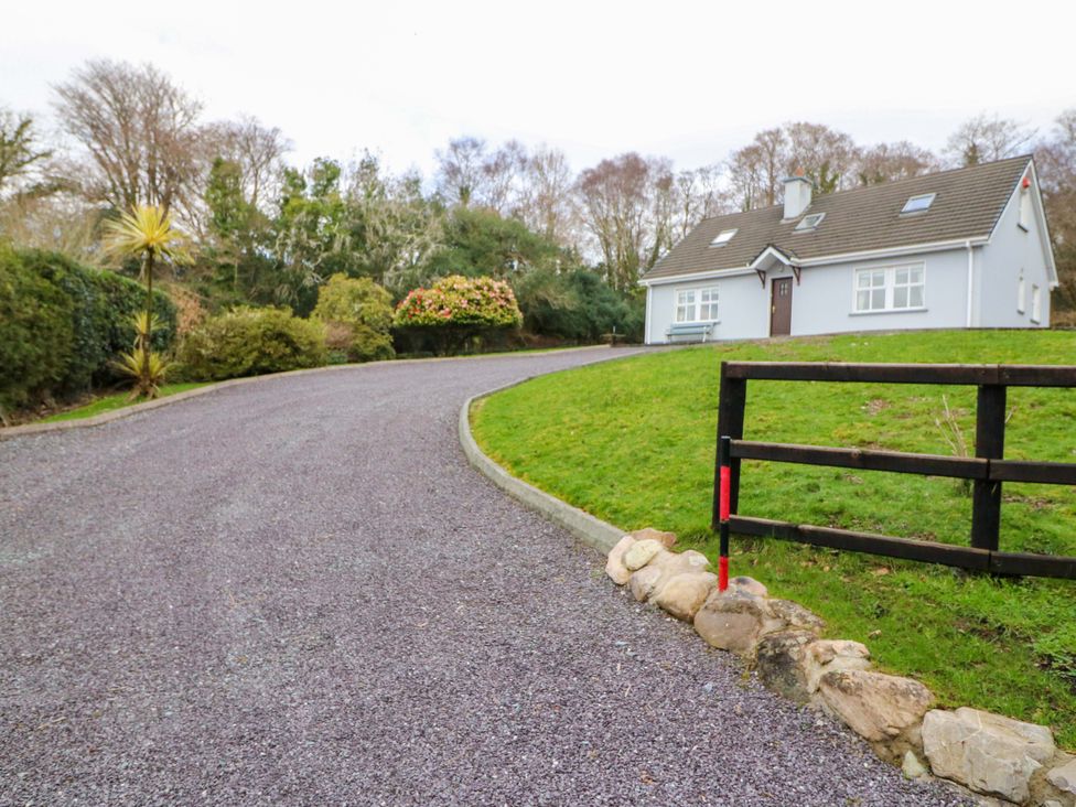An exterior view of a house with a gravel driveway at Lugdine Lodge, Glengarriff