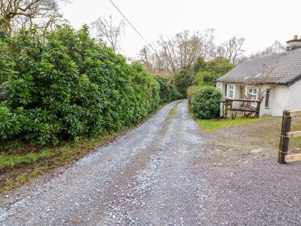 A gravel driveway leading to a cottage at Lugdine Lodge in Glengarriff