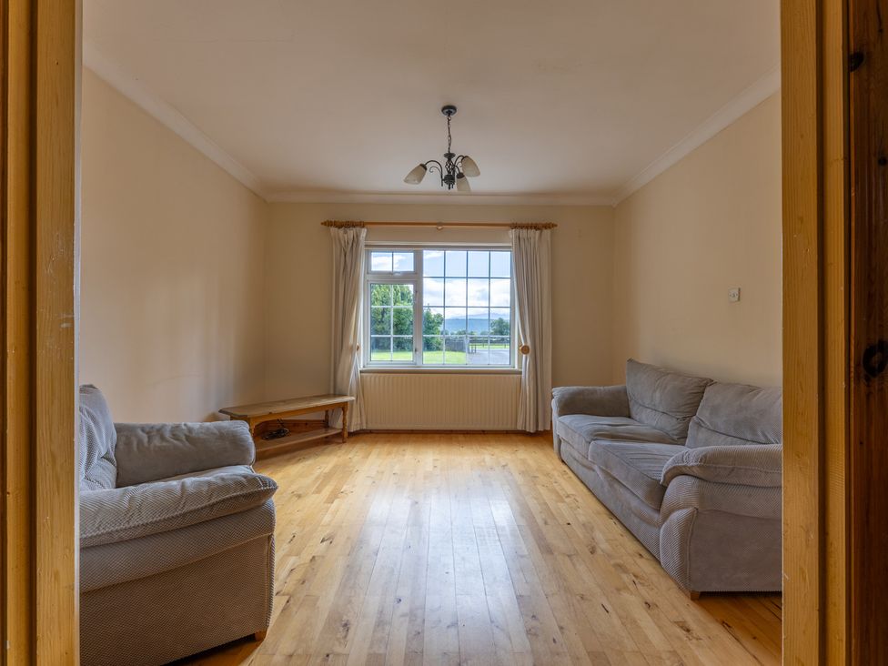 A living room with two sofas and a window at Ballyneill Farmhouse, Carrick-On-Suir, County Tipperary