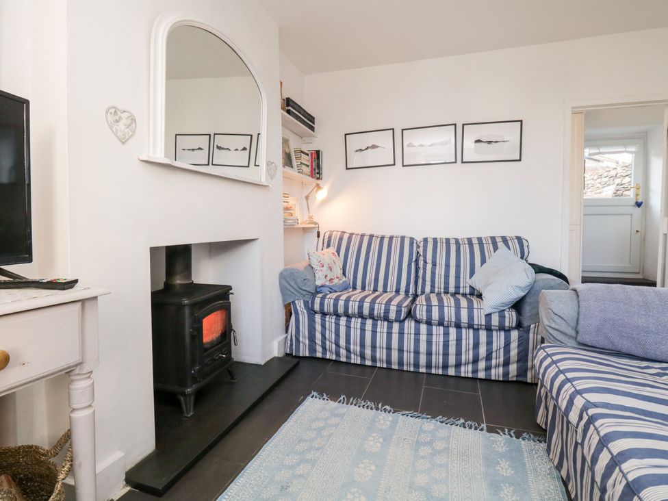 A living room with a television and a fireplace at Burnside Cottage in Grange-Over-Sands