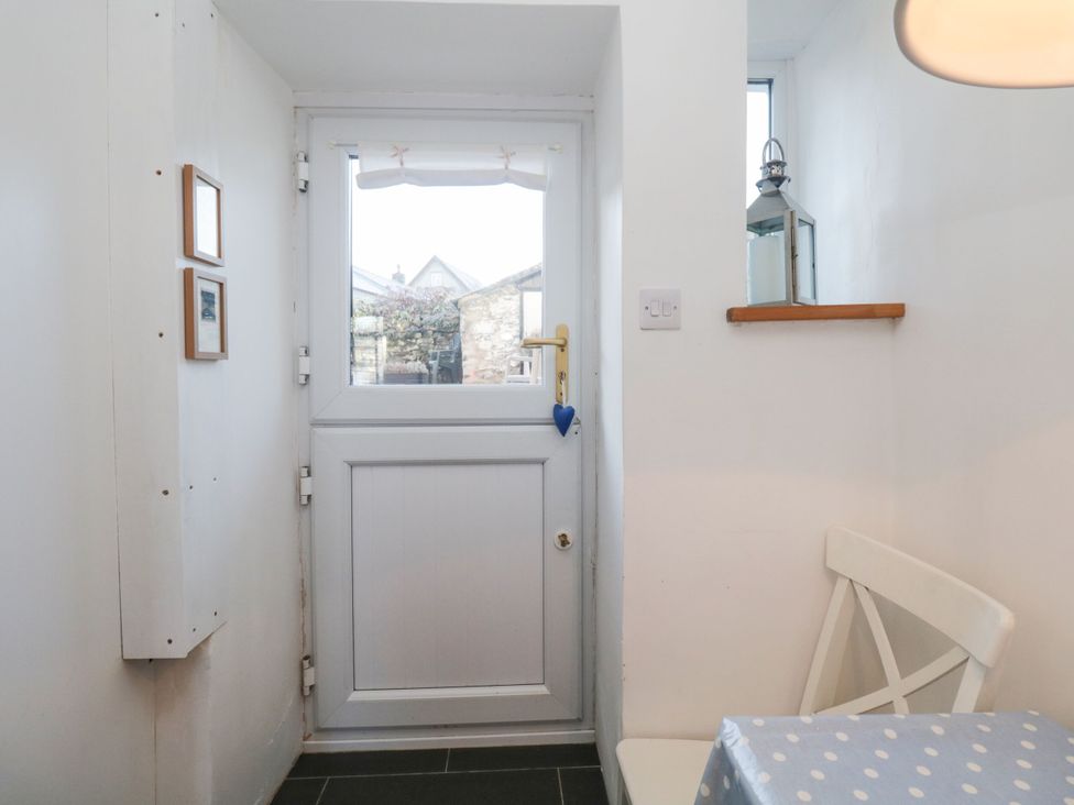 A hallway with a door and a window at Burnside Cottage in Grange-Over-Sands