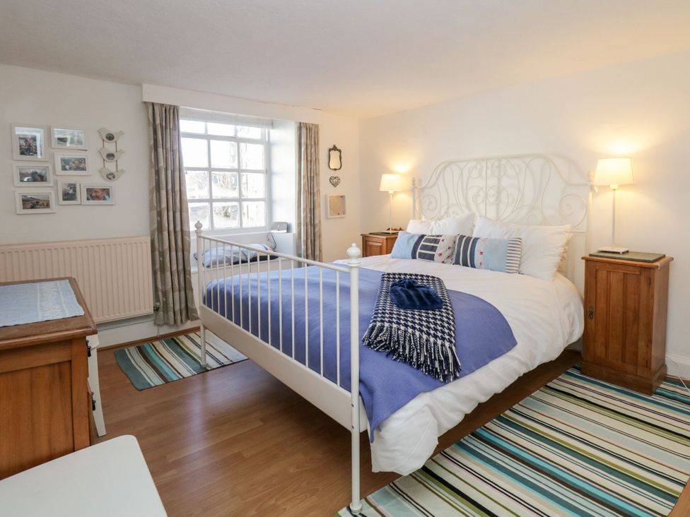 A bedroom with a bed and decorative items at Burnside Cottage in Grange-Over-Sands
