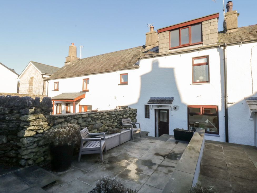 A garden with stone wall and outdoor furniture at Burnside Cottage Grange-Over-Sands