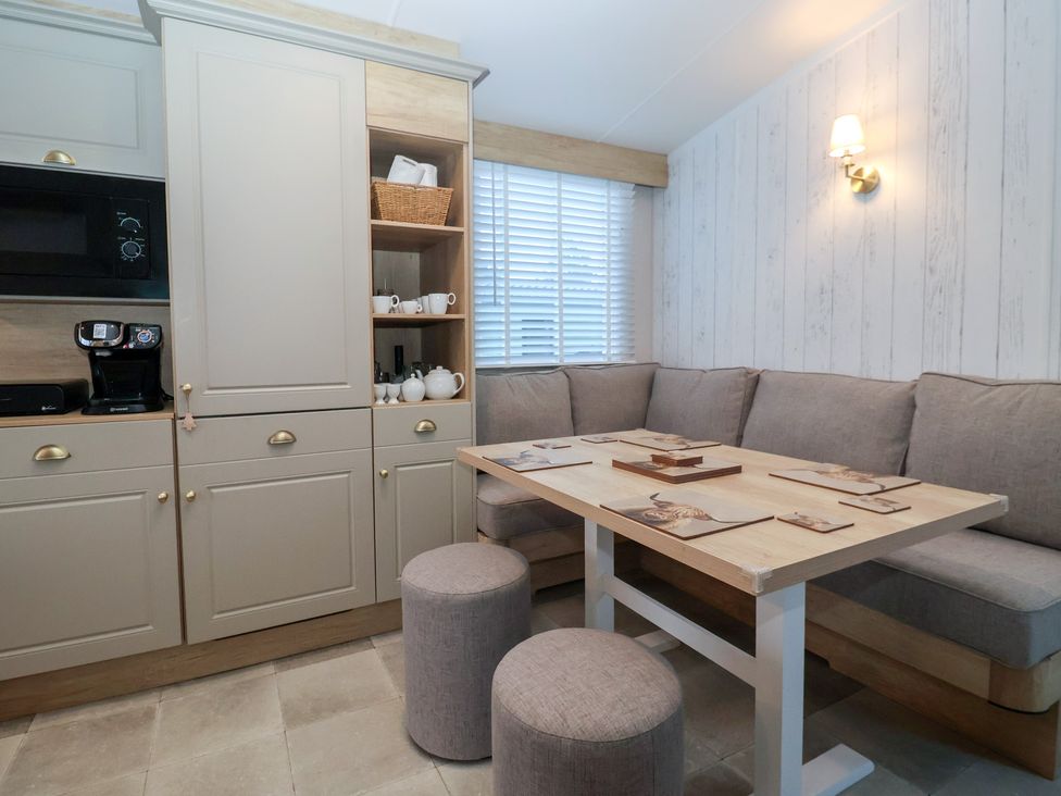 A dining room with a table and sofa at Lodge 22, Moselle in Malton