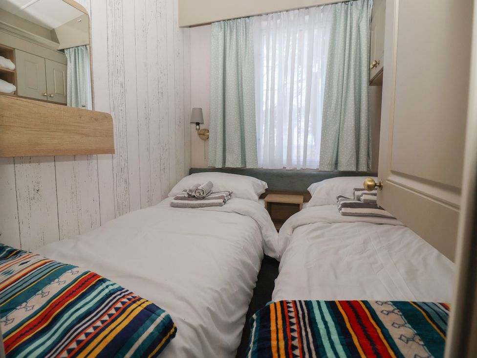 A bedroom with two beds and a bedside table at Lodge 22, Moselle Malton