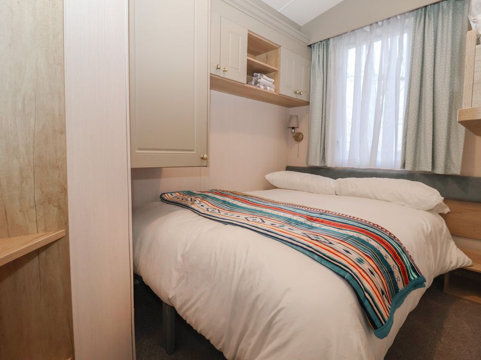 A bedroom with a bed covered by a blanket at Lodge 22, Moselle in Malton