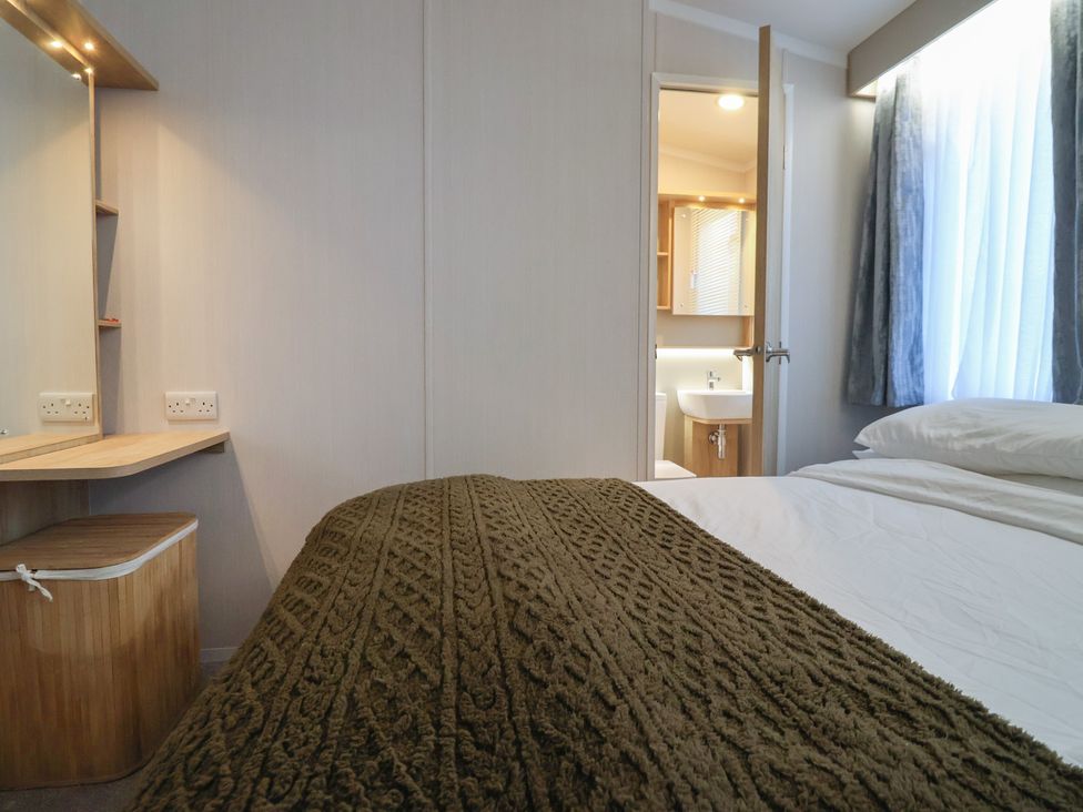 A bedroom with a bed and a door leading to a bathroom at Lodge 22, Moselle Malton