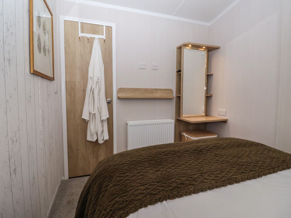 A bedroom with a bed and mirror at Lodge 22, Moselle in Malton