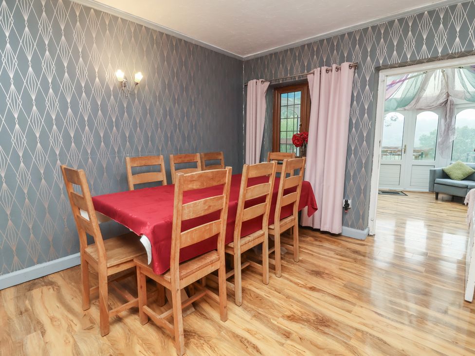 A dining room with a wooden table and chairs at West Down Country House in South Molton