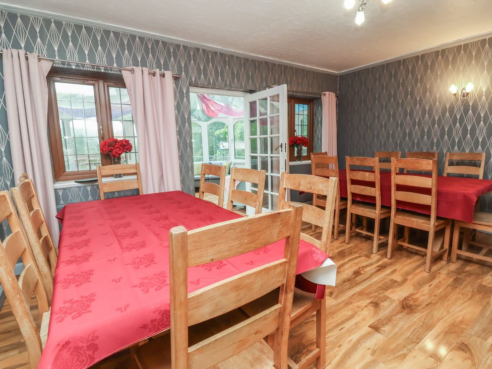 A dining room with a wooden table and chairs at West Down Country House in South Molton