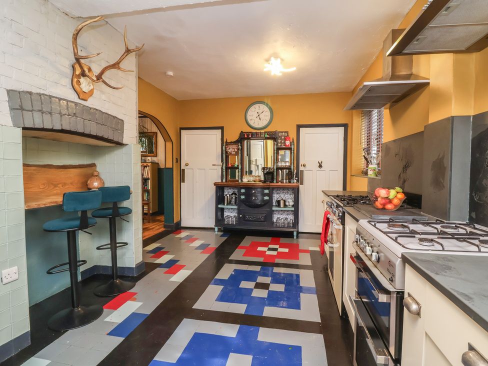A kitchen with bar stools and appliances at West Down Country House in South Molton