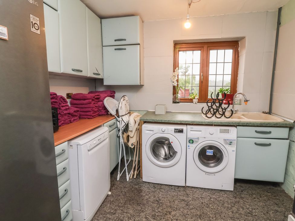 A laundry room with appliances and towels at West Down Country House in South Molton