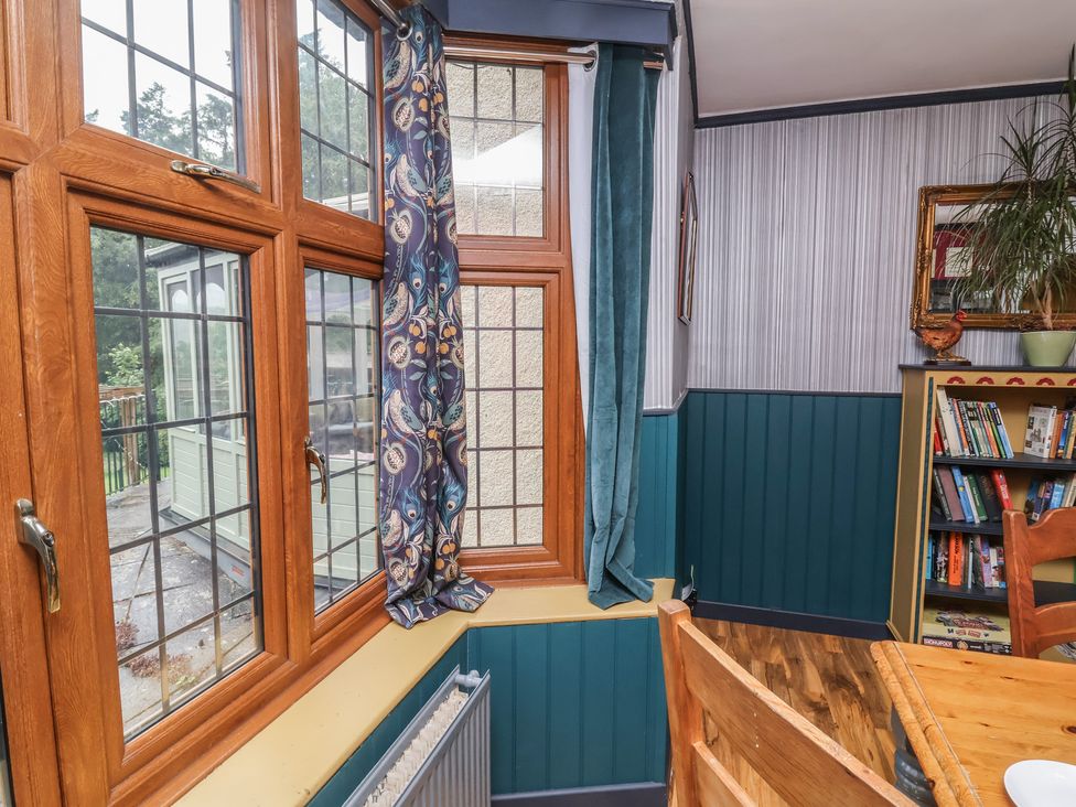 A room with a window, curtains, radiator, and bookshelf at West Down Country House, South Molton