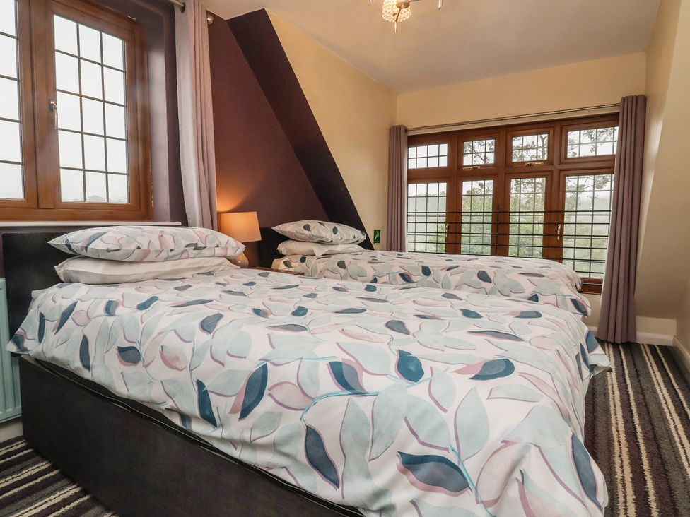 A bedroom with two beds and a window at West Down Country House in South Molton