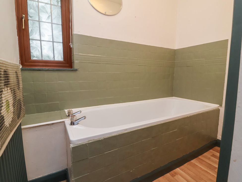 A bathroom with a bathtub and window at West Down Country House in South Molton