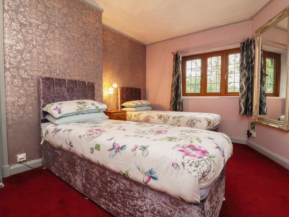 A bedroom with two beds and a window at West Down Country House in South Molton