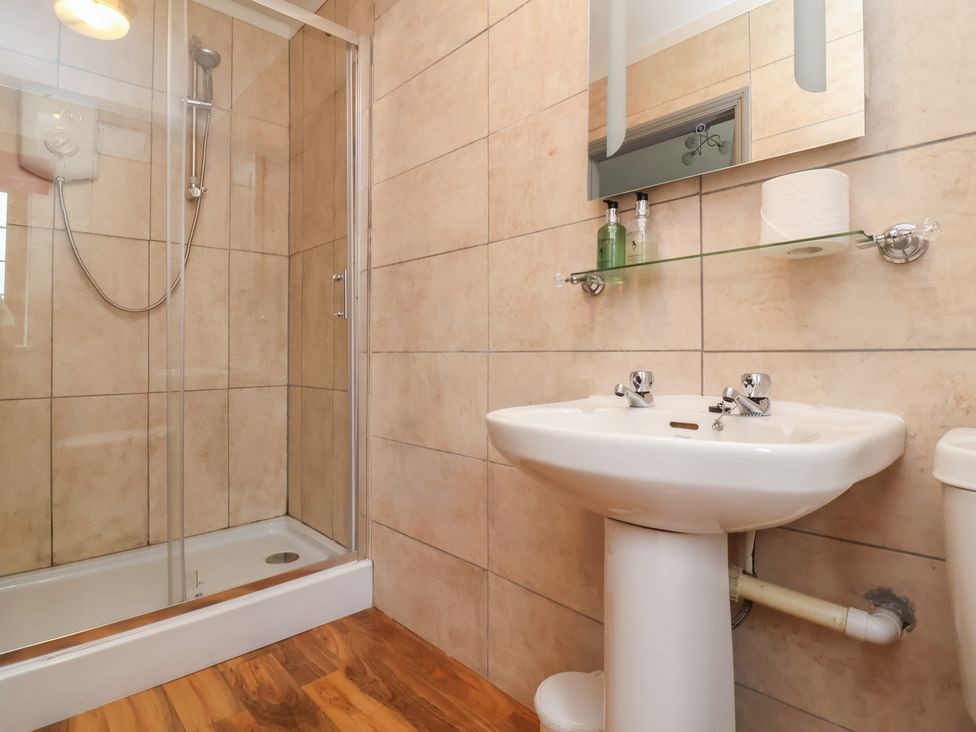 A bathroom with a sink, shower, and toilet at West Down Country House in South Molton