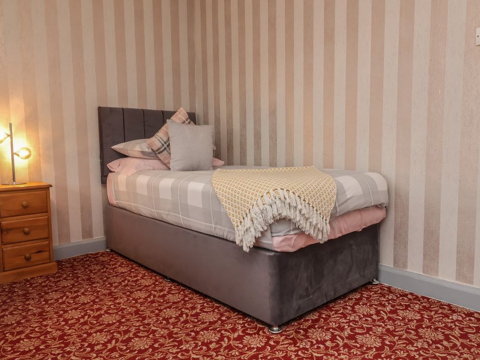 A bedroom with a single bed and wooden bedside table at West Down Country House in South Molton