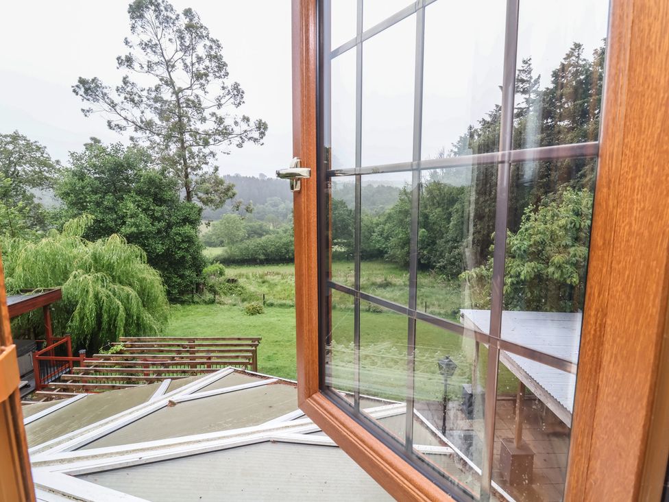 A view from an open window showing trees and a field at West Down Country House in South Molton