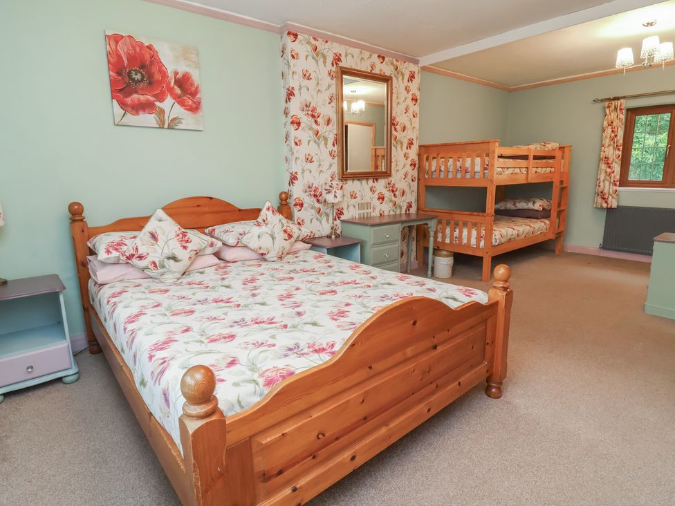 A bedroom with a double bed and a bunk bed at West Down Country House in South Molton