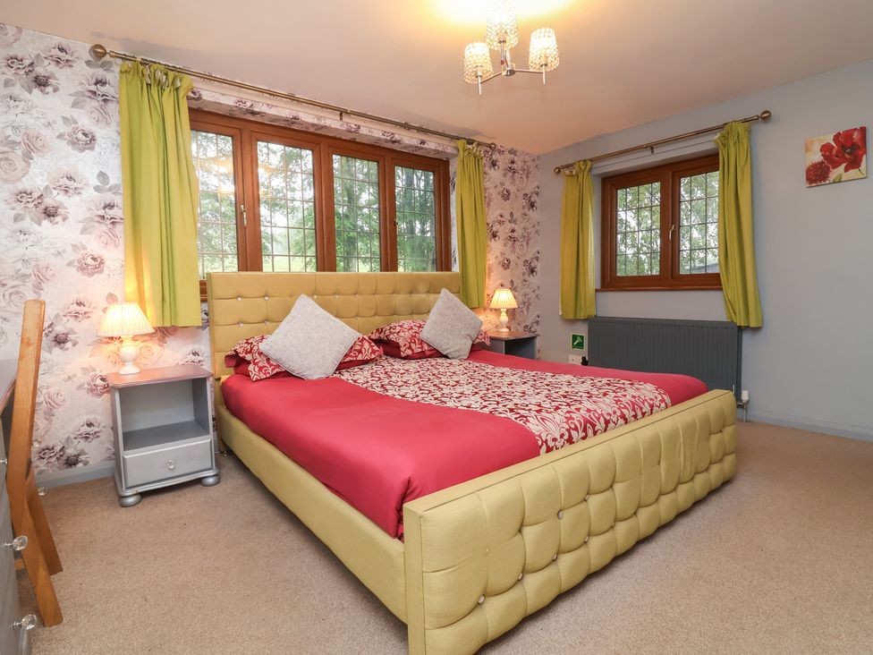A bedroom with a bed and windows at West Down Country House in South Molton