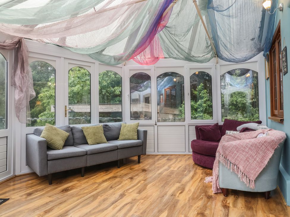 A conservatory with seating and decorative fabric at West Down Country House South Molton